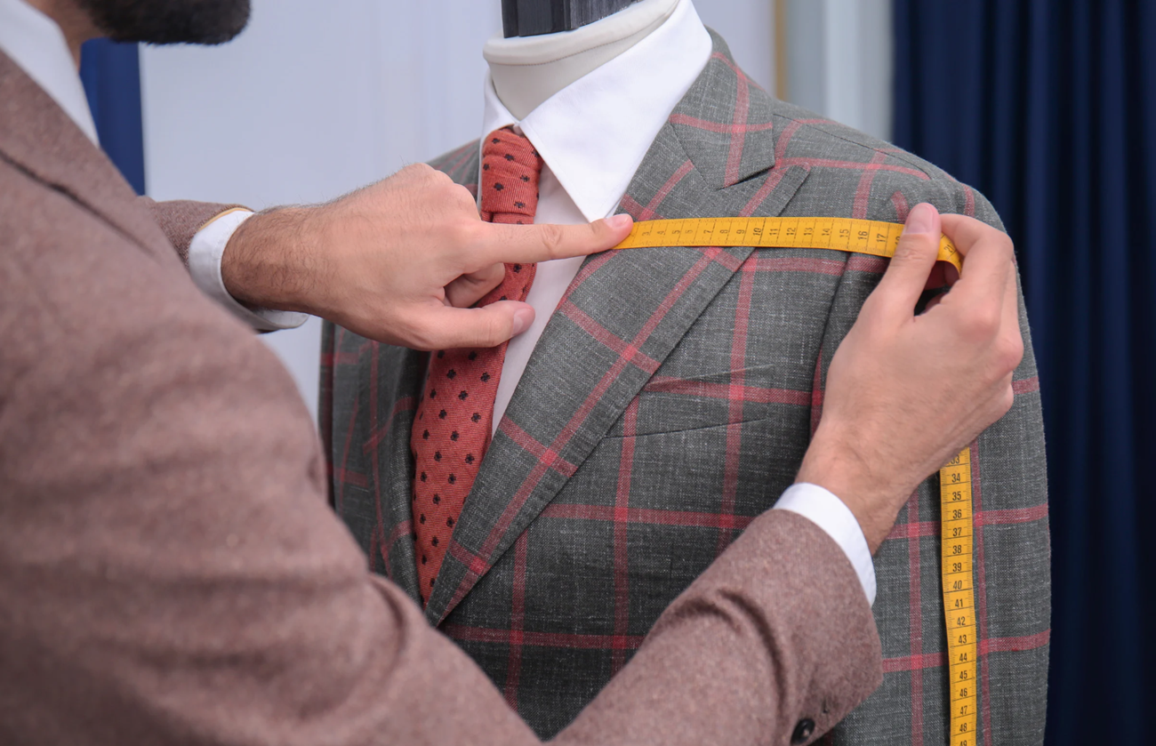 A team of skilled workers in a modern factory carefully stitching and assembling garments, showcasing the precision and expertise of top custom clothing manufacturers in producing high-quality apparel. 